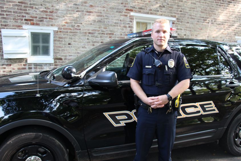 University Police Officer Luke Shivery next to patrol car