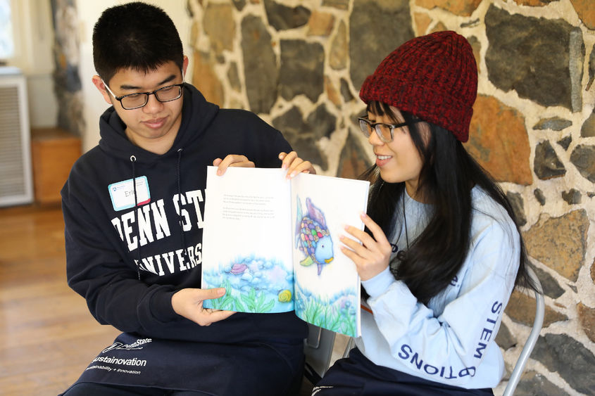 Penn State Brandywine students Eric Tseng and Anna Nguyen read to children at Tyler Arboretum.