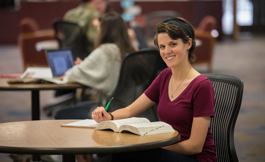 Catherine Mesure sitting in Penn State Brandywine's library.