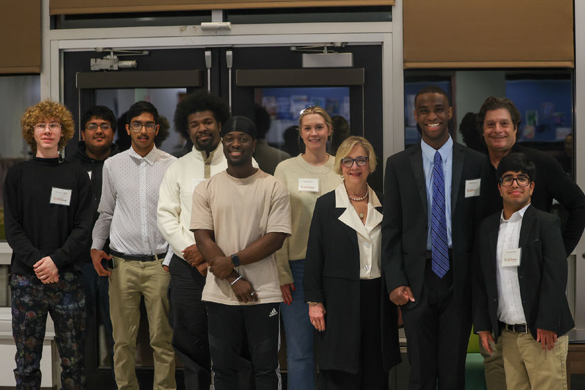 students posing for photo with administrators and coaches