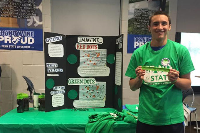 Student holding a Stand for State bracelet