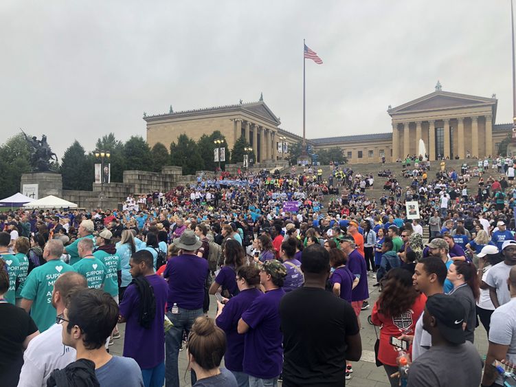 A large crowd of people at a walk that raises funds for the American Foundation for Suicide Prevention.