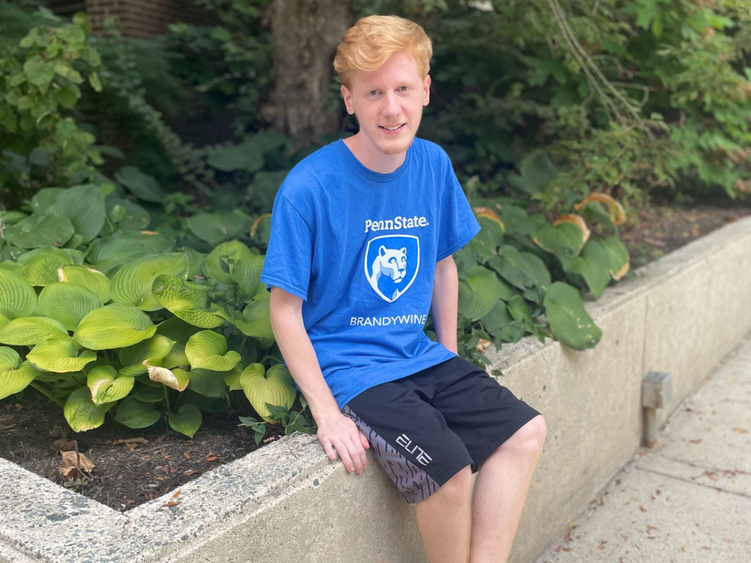 Benjamin Keller sitting next to plants in a Brandywine t-shirt