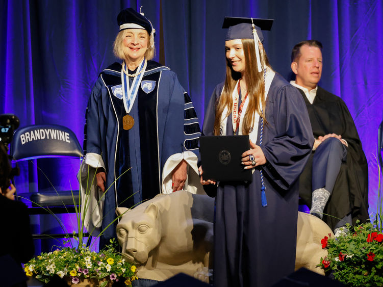 A female student receives her diploma at Brandywine's commencement ceremony.