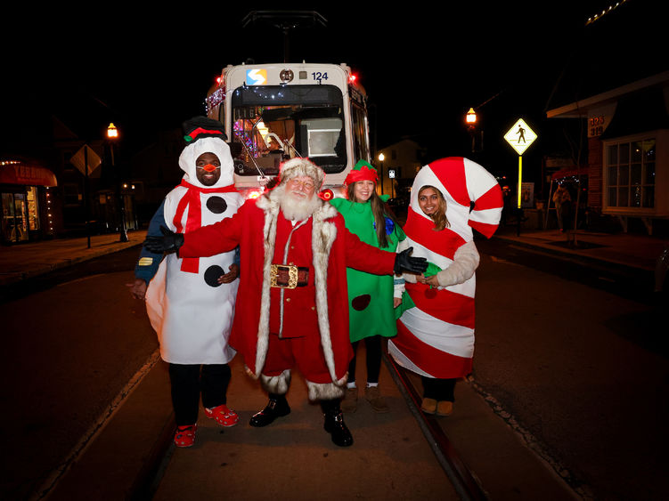 students in snowman, tree and candy cane costumes with Santa