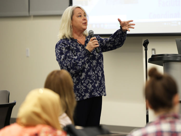 A woman speaks in front of an audience.