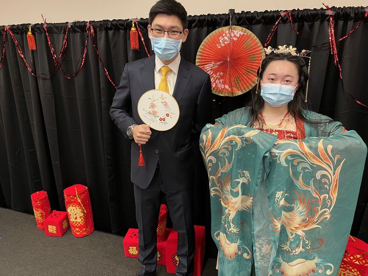 A male student wearing a suit and a female student wearing traditional Chinese clothing.