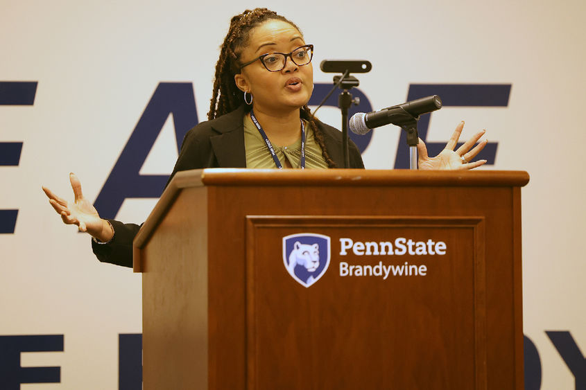 A woman speaks from behind a lectern.