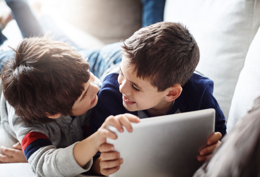 Two children playing on a digital tablet together