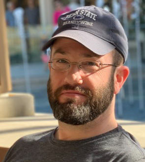 James Berkey smiling and wearing a Penn State Brandywine hat.