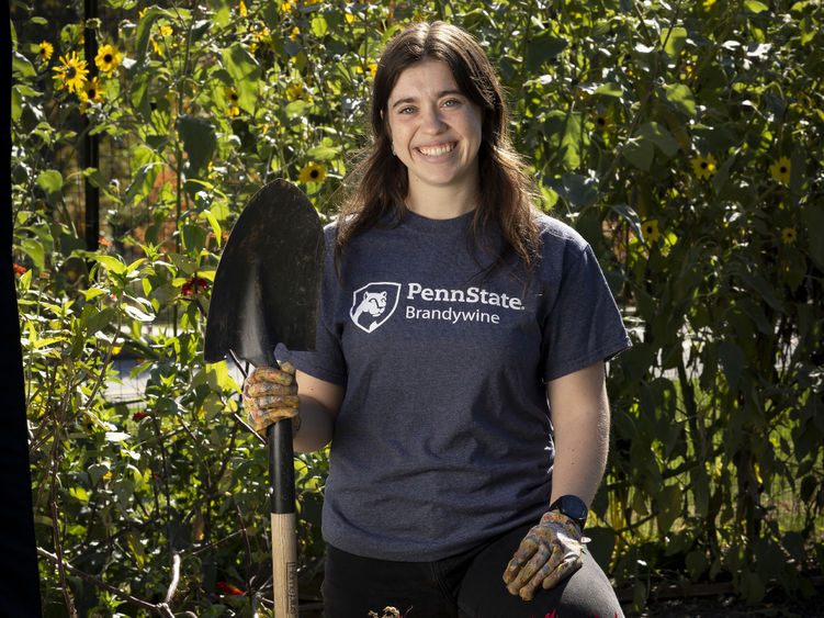 McKenna holding a shovel in a garden