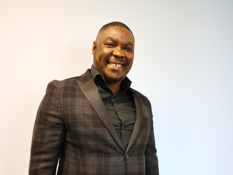 Olugbenga's smiling for his headshot