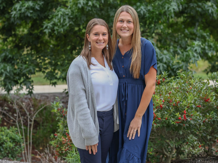 Two women pose for a photo outside on the Penn State Brandywine campus.