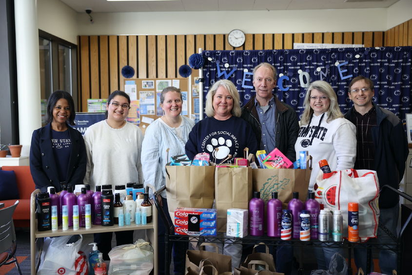a group of people stand behind a display of toiletry items