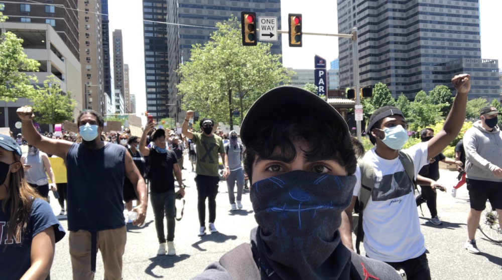 Documentarian Jacob Mejias films ahead of protestors on a Philadelphia street. 