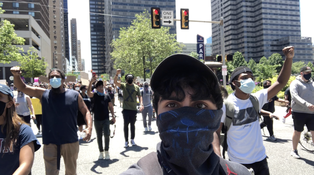 Documentarian Jacob Mejias films ahead of protestors on a Philadelphia street.