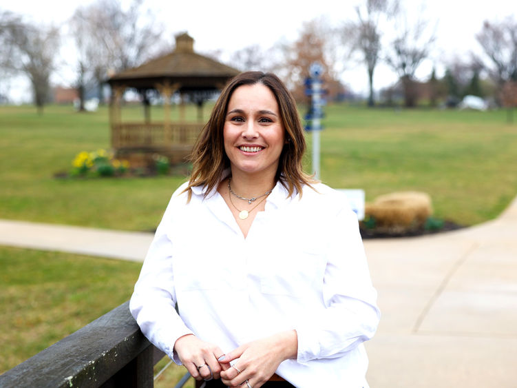 Lady wearing white shirt leaning on a bridge