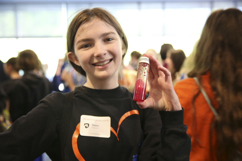 A girl holds a test tube.