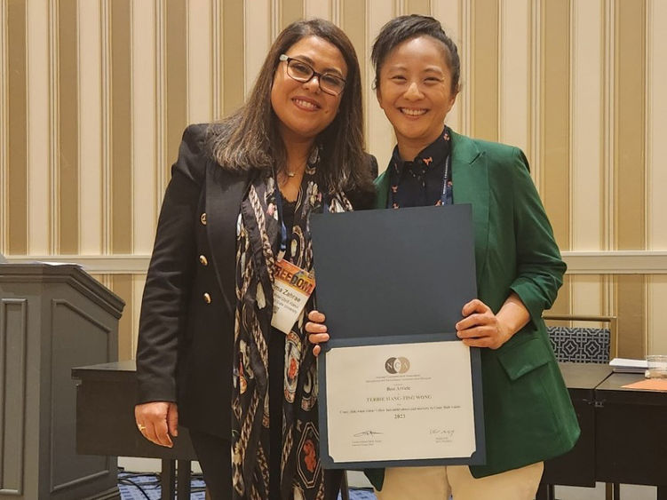 Terrie Wong holding certificate next to woman at National Communication Association conference