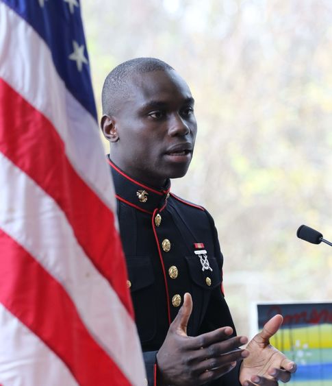 Veteran speaking and standing next to american flag