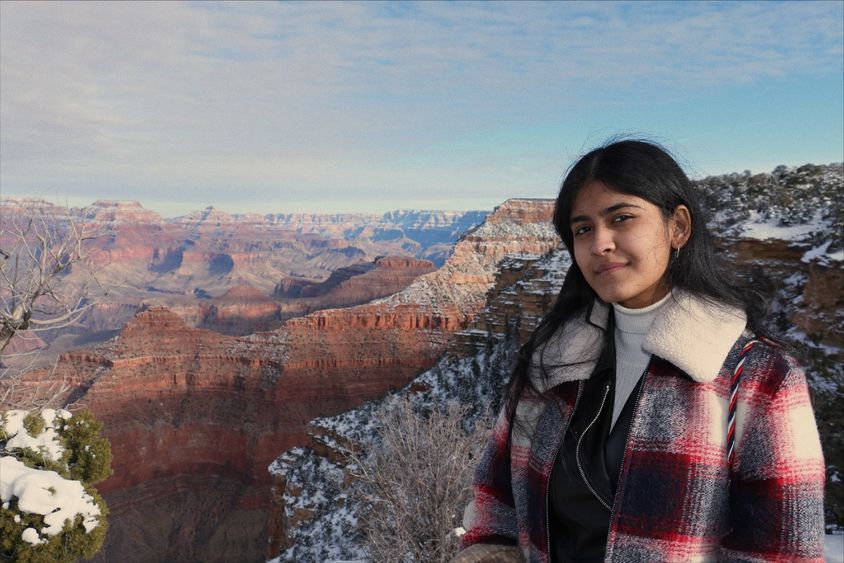 A female stands at the rim of the Grand Canyon.