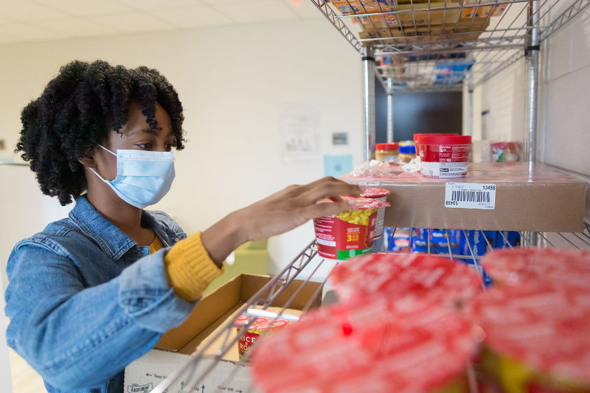 Brandywine student Angel Asomugha stocking the campus food pantry.